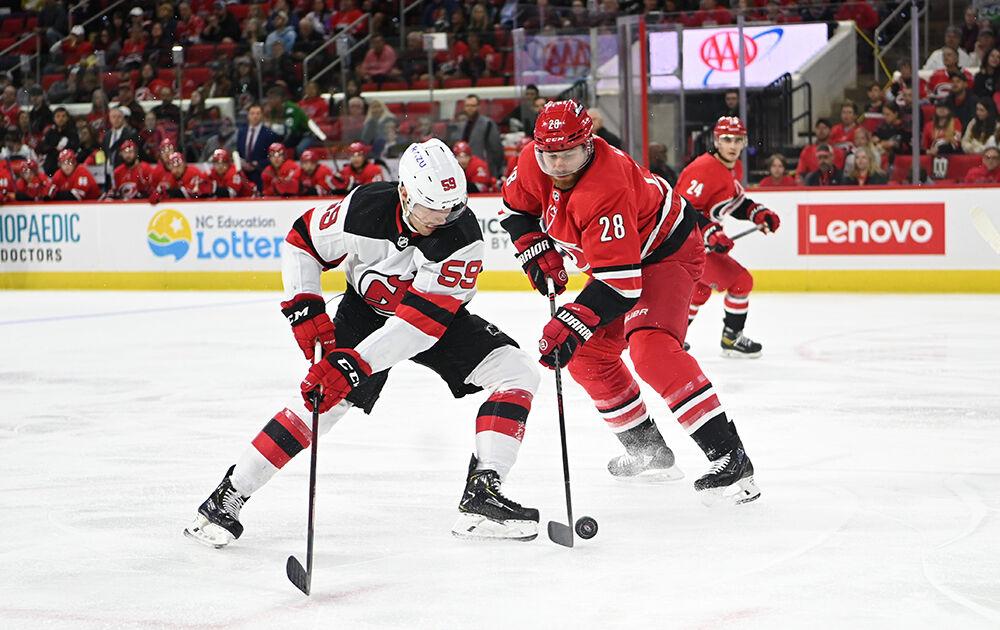 Left defenseman Ian Cole battles for the puck against a New Jersey Devil player during the game in PNC Arena on Thursday, April 28, 2022. The Hurricanes beat the Devils 6-3.