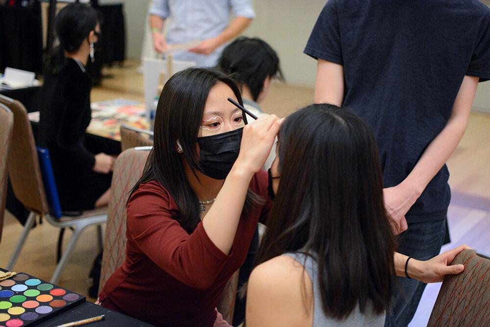 Cathy Thai, a second-year in animal science, paints someone's face during the Asian Artist Showcase hosted by CRANE at Talley Student Union on Friday, April 1, 2022. This year, CRANE (Critical Asian Narratives and Engagement) Collective hosted its first ever Asian Artist Showcase, an event where Asian and Asian American artists can display their artwork to the community.