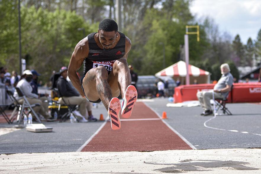 Junior jumper Chris Alexander jumps towards the sand pit during the triple jump event of Raleigh Relays on Friday, March 25, 2022 at Paul Derr Track &amp; Field facility. Alexander finished second with a jump of 15.49.