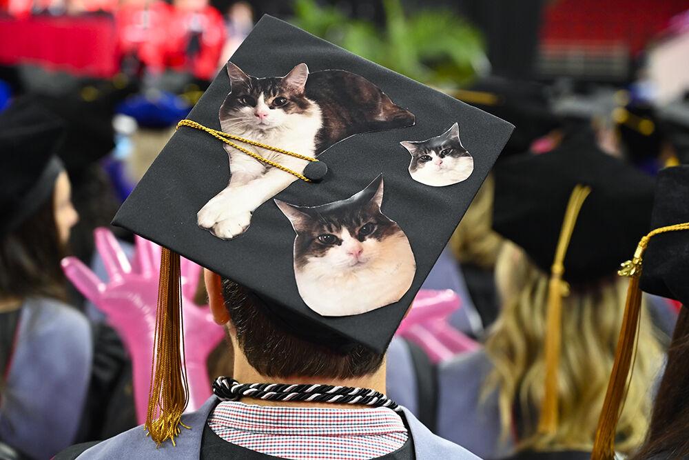 A graduate wears a cap decorated with cats in PNC Arena during NC State's Commencement on Saturday, May 7, 2022.