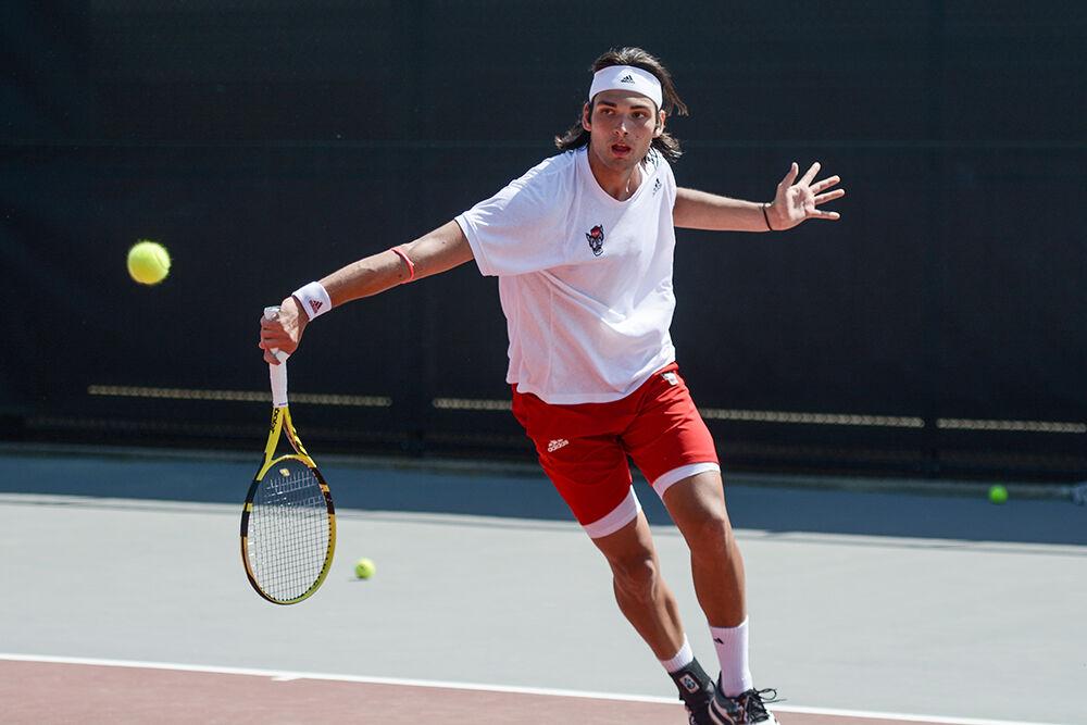 Freshman Damein Salvestre returns a volley in his singles match during the Wolfpack's home tennis match up against the UNC-Chapel Hill Tar Heels at the J.W. Isenhour Tennis Center on Sunday, April 17, 2022. The Wolfpack lost 4-3.