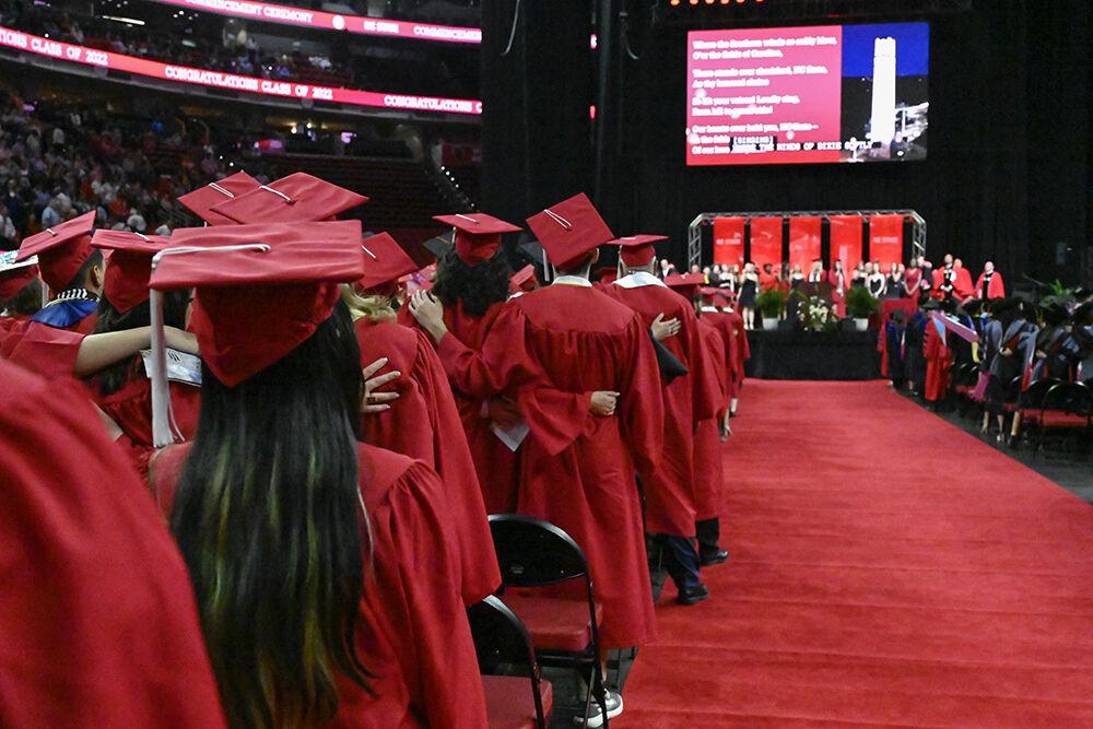 Graduates stand together and sing the NC State Alma Mater during the Spring Commencement ceremony in PNC Arena on Saturday, May 7, 2022.