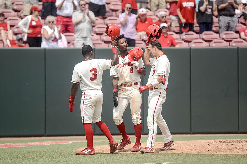 Senior infielder Devonte Brown, sophomore infielder LuJames Groover III and junior infielder Josh Hood congratulate Hood for hitting a home run during the baseball game against Radford at Doak Field on Sunday, May 1, 2022. Hood hit two home runs during the game and the Wolfpack beat the Highlanders 11-4.
