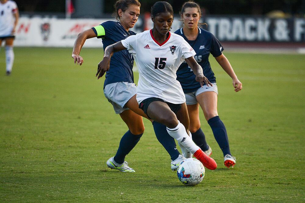 Senior forward Jameese Jospeh shields the ball from two defenders during the match against Georgetown on Sunday, Aug. 28, 2022 at Dail Soccer Field. Jospeh had one goal during the match. The Wolfpack tied the match 2-2.