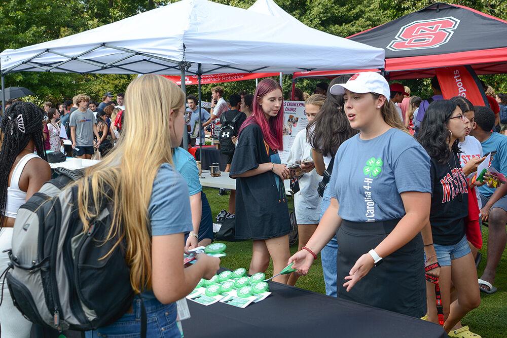 Bliss Pointer, a first-year student studying agricultural business management, explains the North Carolina 4-H club to a fellow student at the Student Involvement Fair at Stafford Commons on Friday, Aug. 26, 2022. The Student Involvement Fair was an event to have NC State clubs interact directly with students.