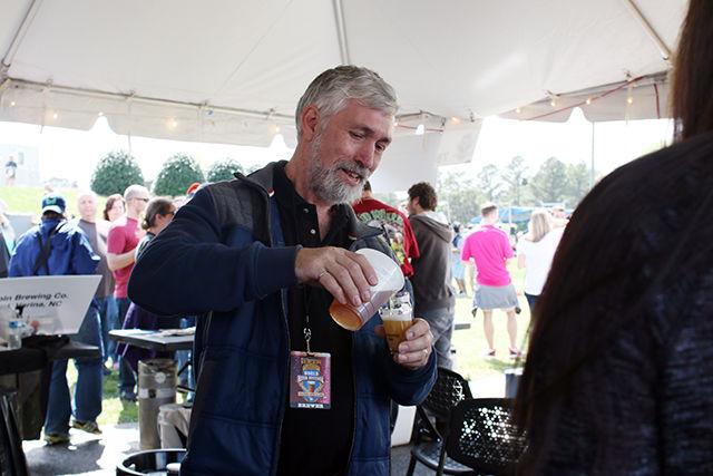 John Sheppard, professor and undergraduate coordinator of the bioprocessing science program at NC State, serves samples of beer brewed using the program's research brewing supplies during the World Beer Festival held at the NC State Fairgrounds on April 2. Sheppard and his program serve brewing samples to over 50 NC State campus events per year and recently received their license to sell alcohol.