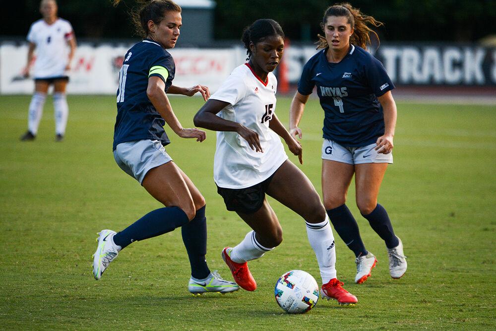 Senior forward Jameese Jospeh shields the ball from two defenders during the match against Georgetown on Sunday, Aug. 28, 2022 at Dail Soccer Field. Jospeh had one goal during the match. The Wolfpack tied the match 2-2.