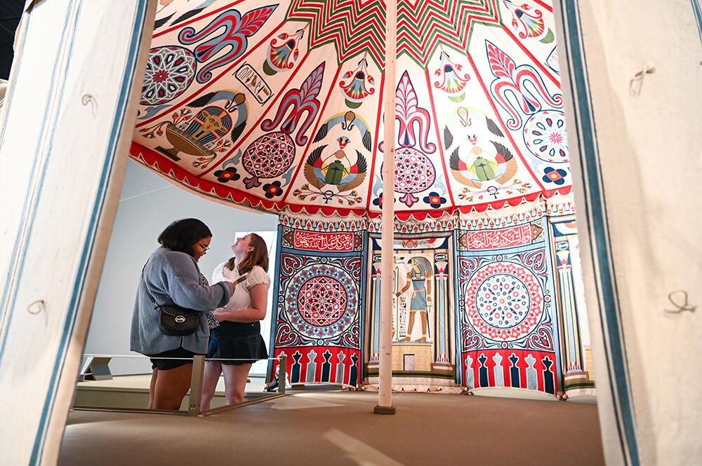 Nicole Page, left, incoming first-year in genetics, and her friend Nikki Berkhof, a student at East Carolina, take in the panels inside an Egyptian tent exhibit at the Gregg Museum on Saturday, Aug. 6, 2022. "I wasn't expecting an Egyptian exhibit, so that was cool," said Page. "I've done a lot of projects on heiroglyphics. I went through a whole Egyptian phase."