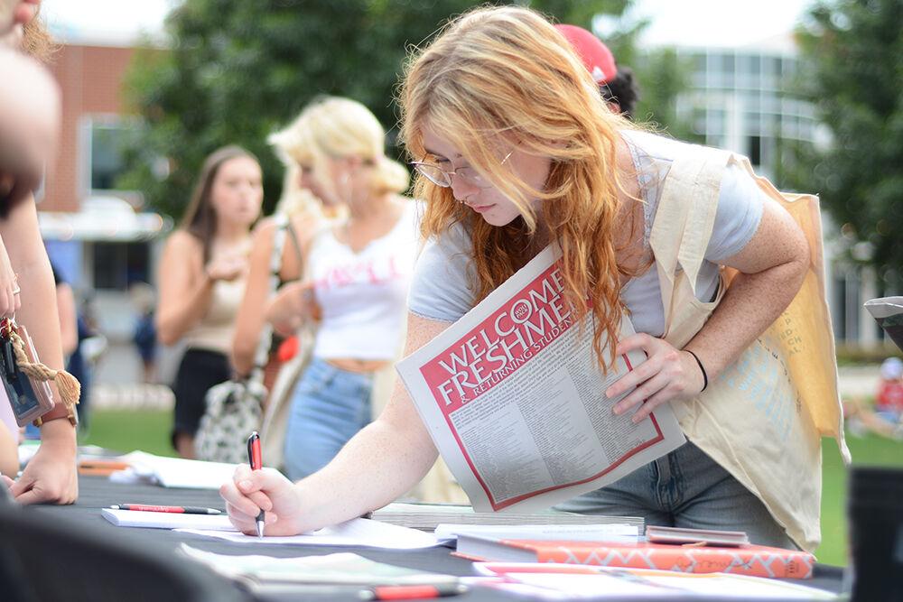 Megan Hutchens, a first-year in exploratory studies, writes her name down on the Student Media interest form during the Witherspoon Block Party at Harris Field on Monday, Aug. 22, 2022. Witherspoon's Block Party was an event during Wolfpack Welcome Week that was for helping students get involved with the organizations that are in Witherspoon Student Center.