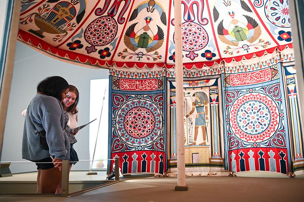 Nicole Page, left, incoming first-year in genetics, and her friend Nikki Berkhof, a student at East Carolina, read a descriptive pamphlet about the layout of panels inside an Egyptian tent exhibit at the Gregg Museum on Saturday, Aug. 6, 2022. "I wasn't expecting an Egyptian exhibit, so that was cool," said Page. "I've done a lot of projects on heiroglyphics. I went through a whole Egyptian phase."