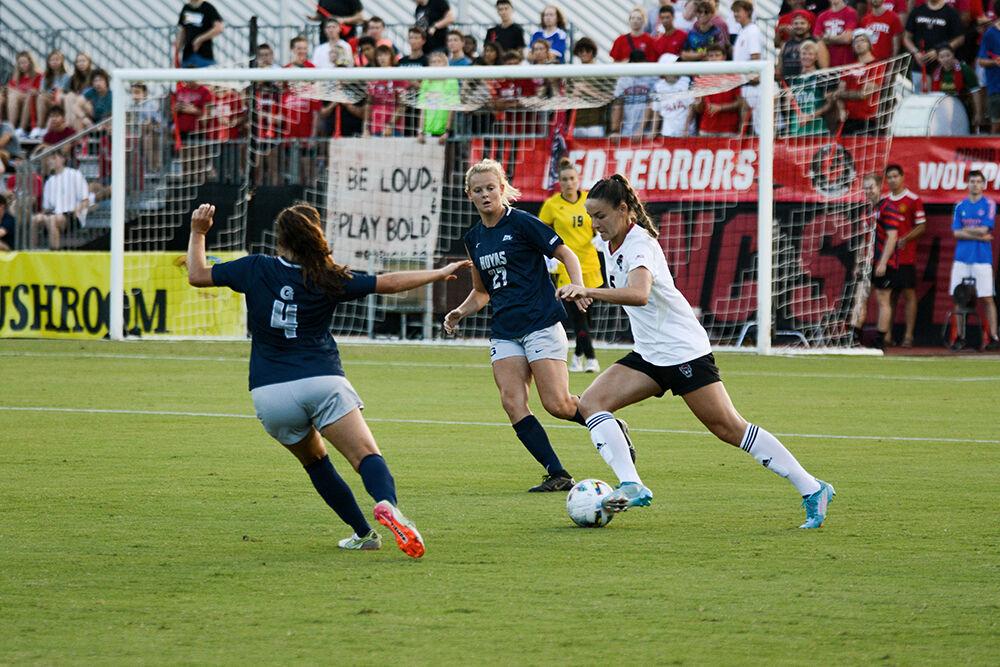 Graduate Jenna Butler dribbles the ball upfield past two defenders during the match against Georgetown on Sunday, Aug. 28, 2022 at Dail Soccer Field. Butler had one goal during the match. The Wolfpack tied the match 2-2.