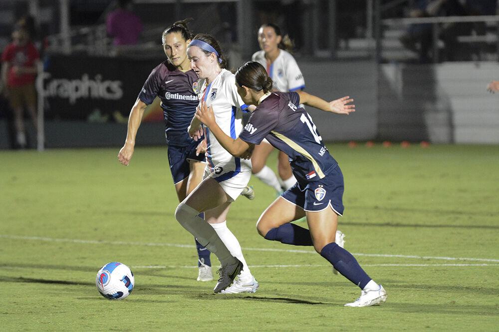 Reign midfielder Rose Lavelle dribbles between Courage defenders Kaleigh Kurtz, left, and Fuka during the NC Courage match against OL Reign on Friday, Sept. 17, 2022. OL Reign won the match 2-1.