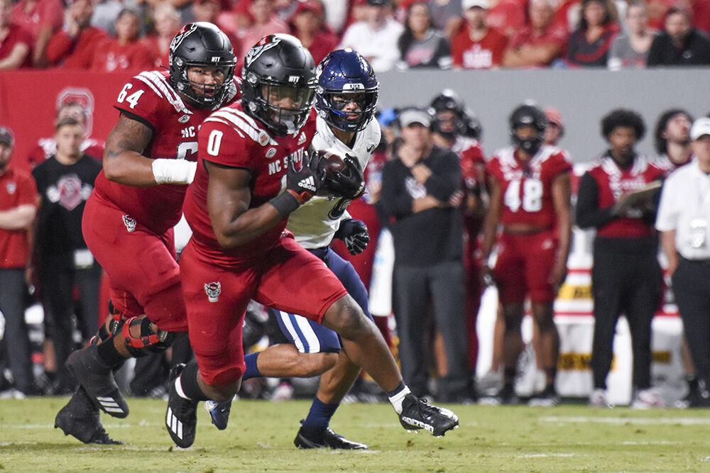 Sophomore running back Demie Sumo-Karngbaye runs away from his opponents during the football game against UConn at Carter-Finley Stadium on Saturday, Sept. 24, 2022. NC State beat UConn 41-10.