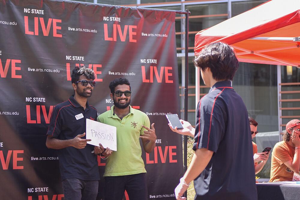 Nagaraj Madamshetti, a graduate student studying computer science, poses with Sai Charan Reddy Pisanti, a graduate student, at the NC State LIVE block party event at Stafford Commons on Sunday, Sept. 18, 2022. NC State LIVE celebrated its 50th Anniversary with a performance from Squonk, Wolfgang A Cappella, Fusion Dance Crew, interactive crafts and food.
