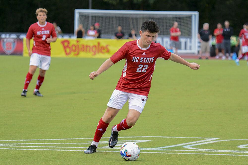Graduate midfielder Conor Kelly kicks the ball forward during the exhibition game against Queens University at Dail Soccer Field&#160;on Sunday, Aug. 14, 2022. NC State beat Queens University 6-0.