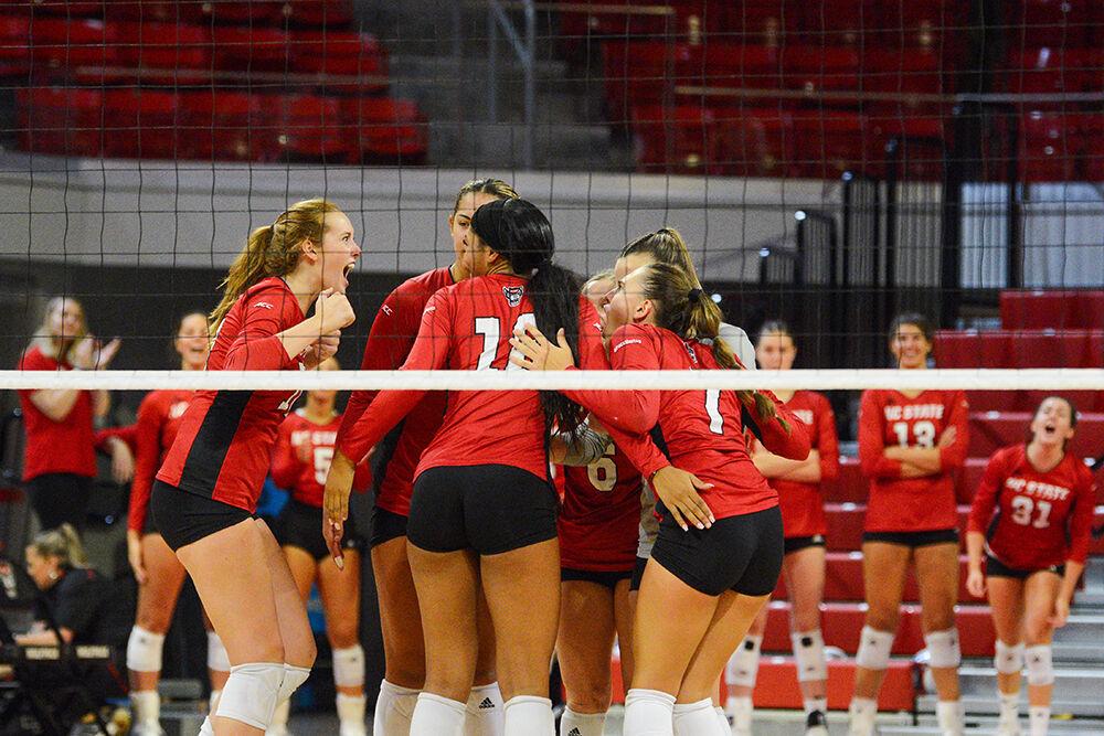 The team huddles to celebrate scoring a point in the game against Elon on Saturday, Sept. 3, 2022 in Reynolds Coliseum. NC State won the game 3-1 against Elon.