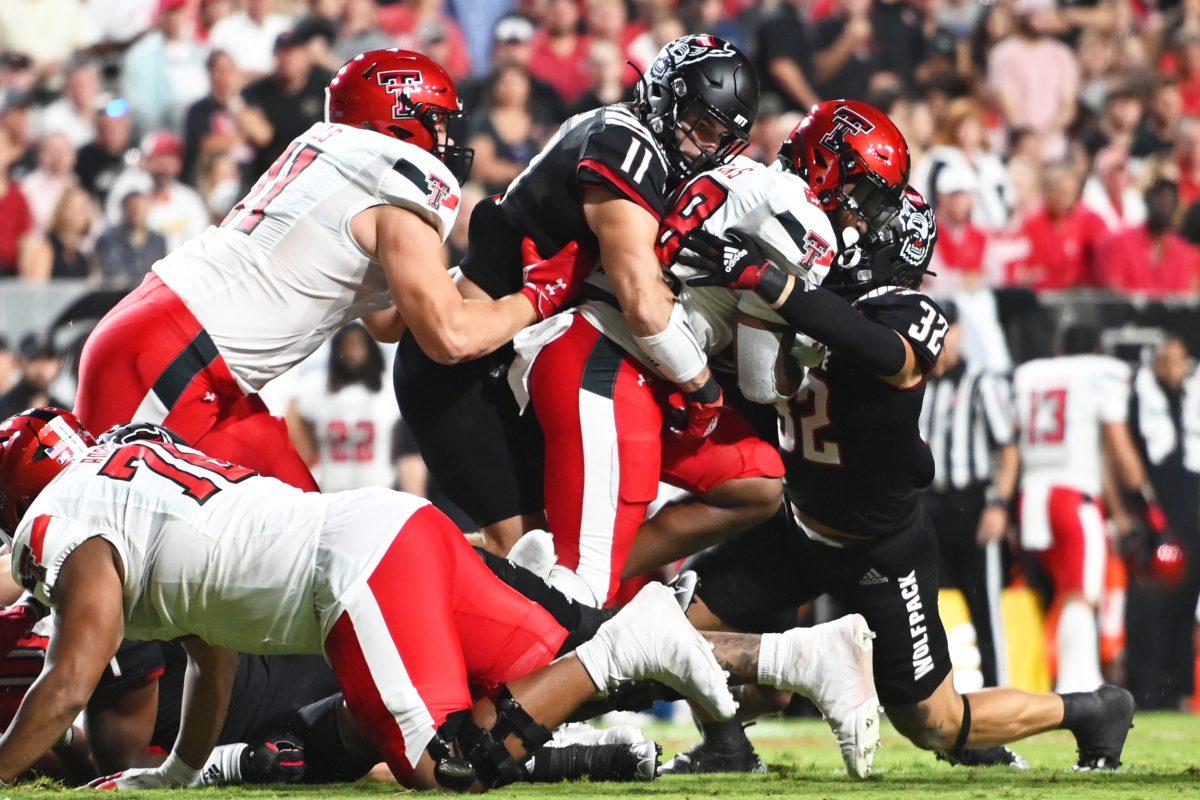 Redshirt junior linebacker Peyton Wilson and junior linebacker Drake Thomas complete a tackle in the game against the Texas Tech Red Raiders at Carter-Finley Stadium on Saturday, Sept. 17, 2022. The Wolfpack won 27-14.
