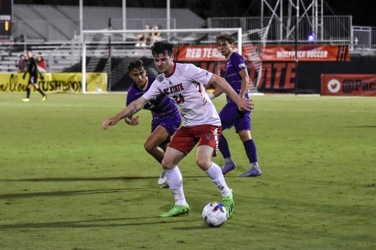 Senior defender Cam Murray dribbles the ball away from an opponent during the match against James Madison on Tuesday, Sept. 13, 2022 at Dail Soccer Field. NC State lost 1-0 to James Madison.