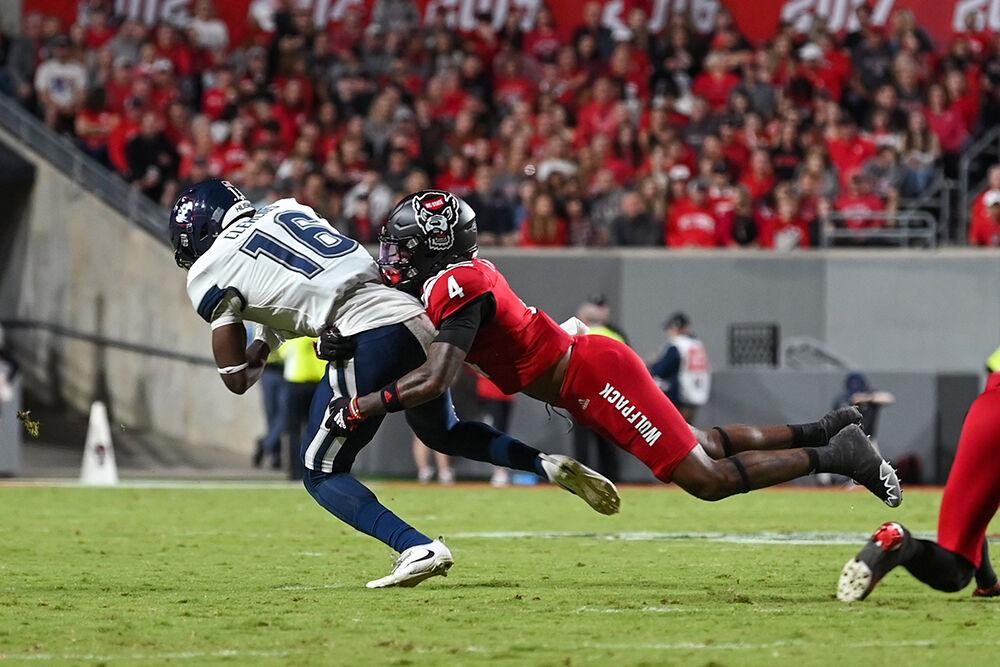 Graduate safety Cyrus Fagan tackles a UConn player during the game in Carter-Finley Stadium on Saturday, Sept. 24, 2022. The Wolfpack beat the Huskies 41-10.