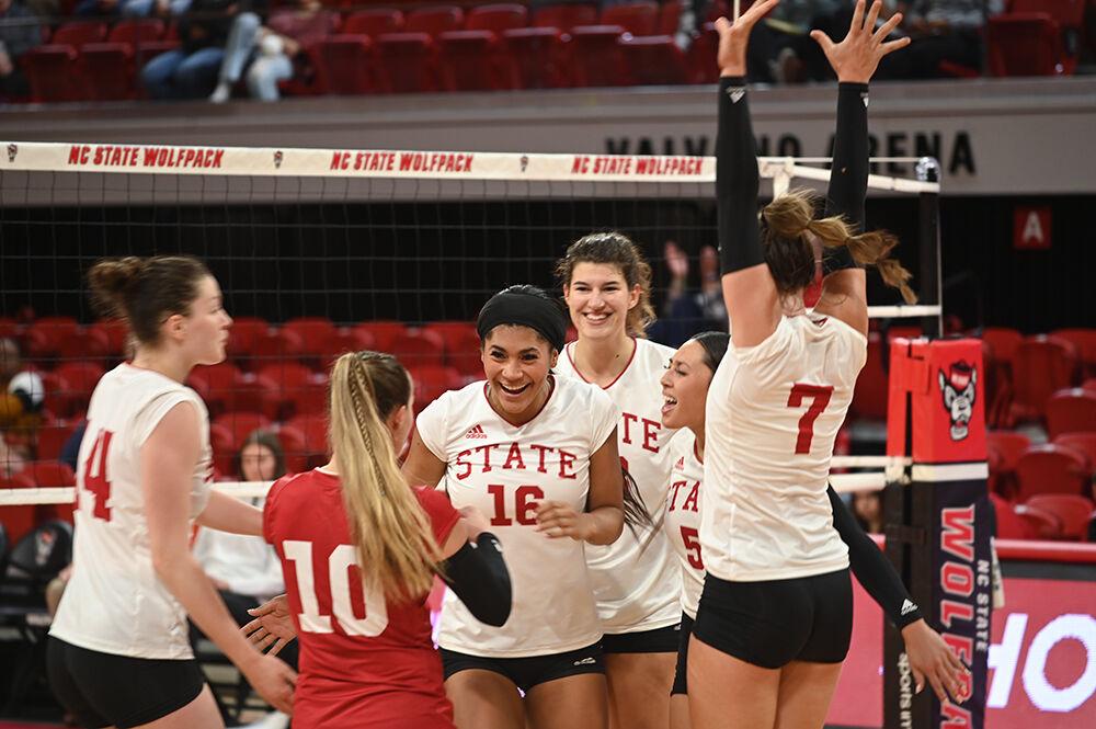 The NC State volleyball team celebrates a kill during the game against Clemson on Friday, Oct. 28, 2022 in Reynolds Coliseum. NC State won the game 3-0 against Clemson.