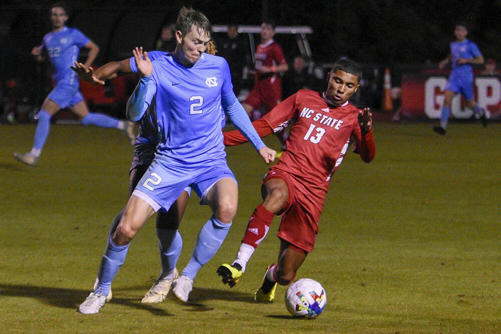 Freshman midfielder Calem Tommy slides in an attempt to steal the ball during the match against UNC-Chapel Hill on Friday,&#160;Oct. 14, 2022 at Dail Soccer Field. NC State tied 2-2 with UNC-Chapel Hill.