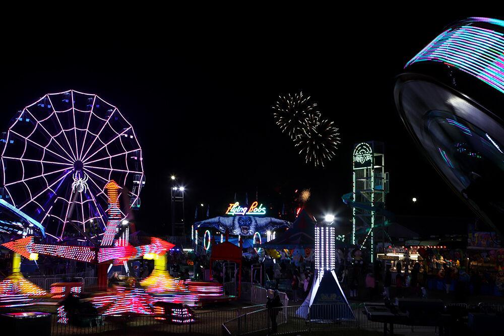 Fireworks are seen at the North Carolina State Fair while fairgoers ride attractions in Raleigh on Friday, Oct. 21, 2022.