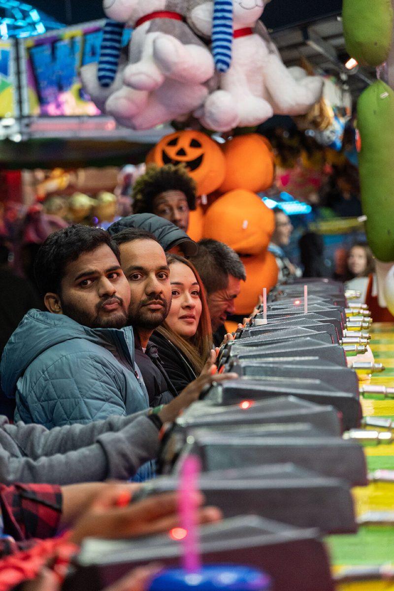 Fairgoers prepare to play a carnival game at the North Carolina State Fair in Raleigh on Friday, Oct. 21, 2022. The NC State Fair was held Oct. 13-23.