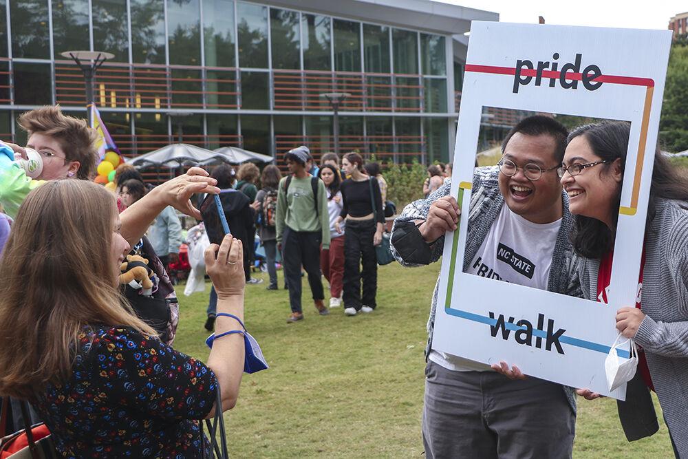 Office of International Services staff Kory Sopko, Ray Espinol and Courtney Klauber take photos during the Pride Walk on Monday, Oct. 3, 2022 around main campus. Members of NC state community joined the Pride Walk to celebrate National Coming Out Day.