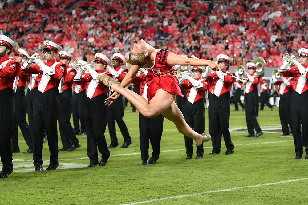 Twirler Claudia Swauger, a third-year studying nutrition science, performs at halftime with the NC State Marching Band during the game versus UConn at Carter-Finley Stadium on Saturday, Sept. 24, 2022. NC State beat UConn 41-10.