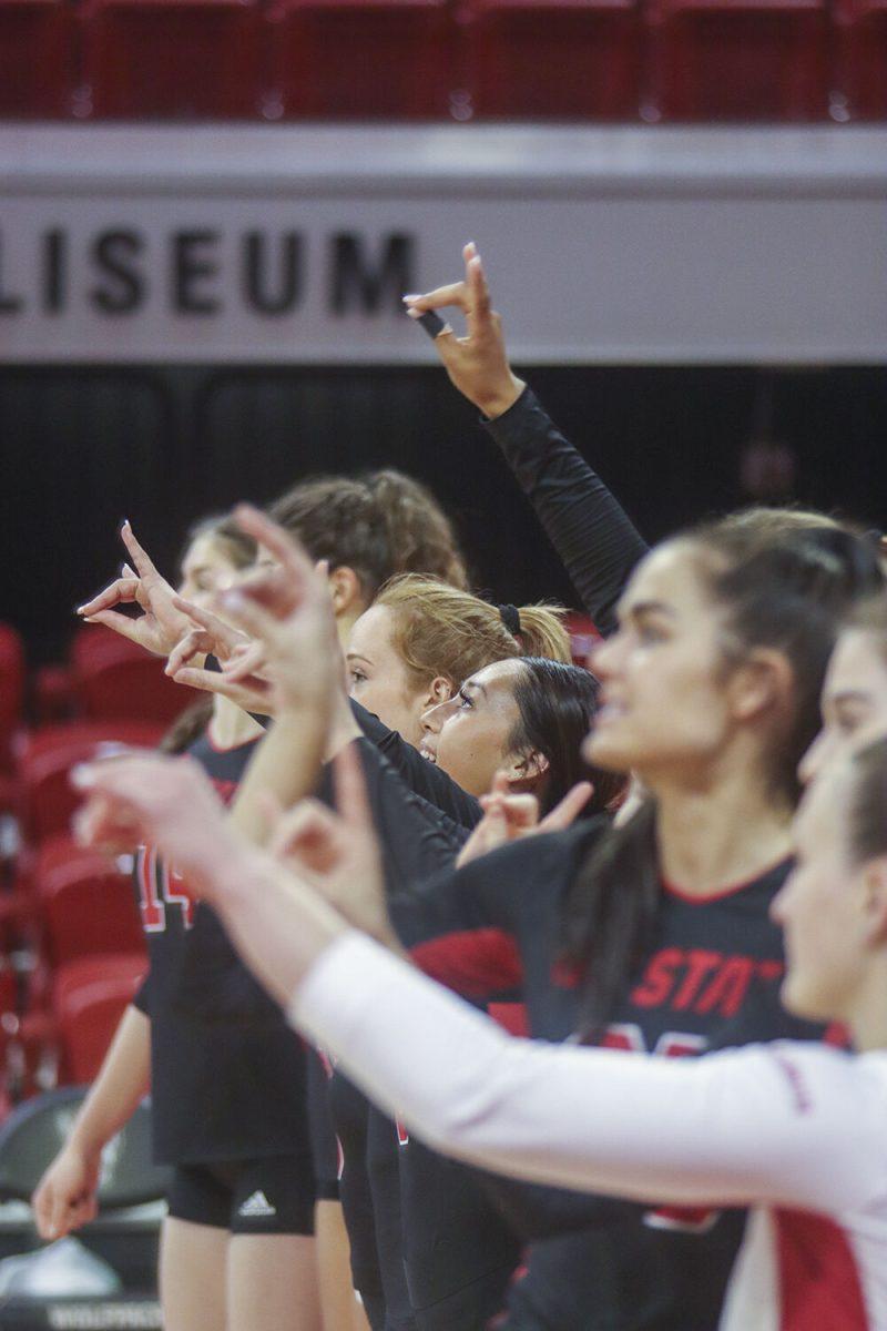 The NC State volleyball team celebrate to the school's alma mater after beating the Miami Hurricanes 3-1 on Sunday,&#160;Oct. 2, 2022, in Reynolds Coliseum.