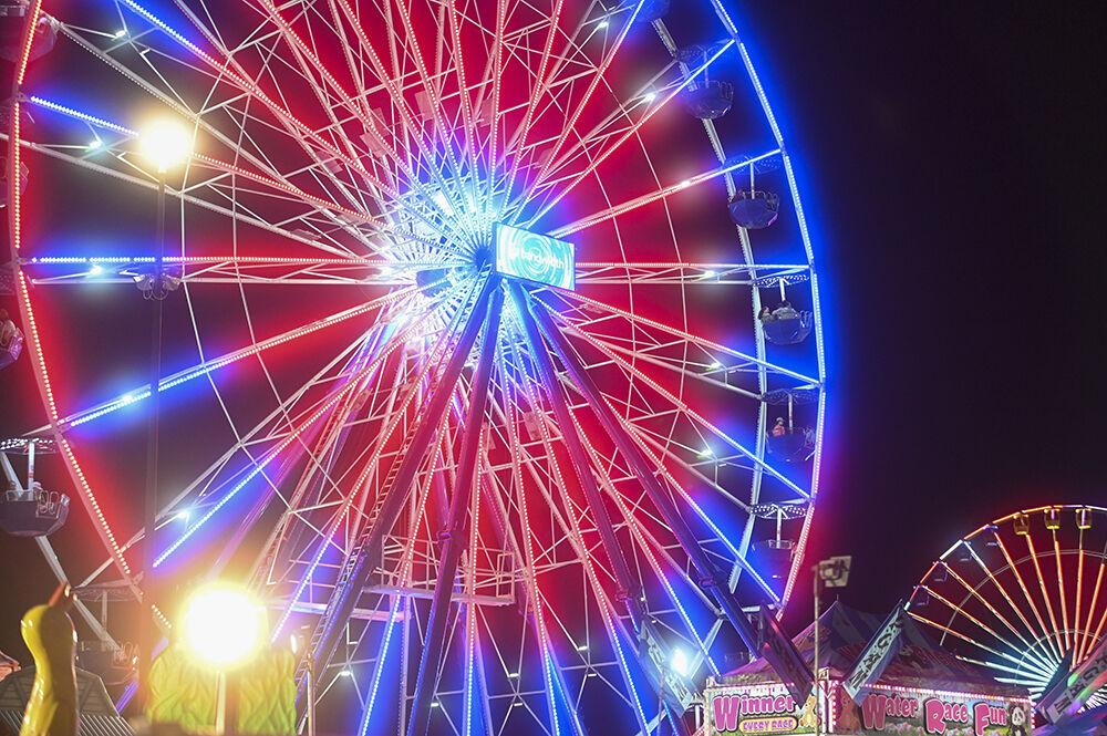 Fair attendees ride a Ferris Wheel at the North Carolina State Fair in Raleigh, on Thursday, Oct. 13, 2022. The NC State Fair was held Oct. 13-23.