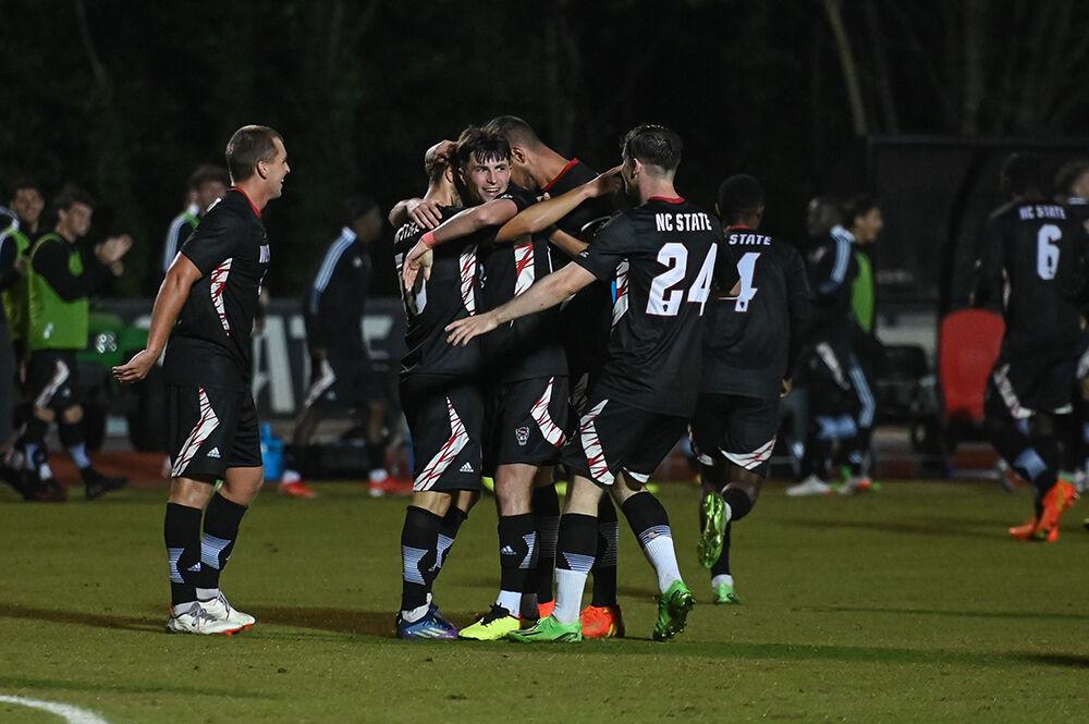 The NC State men's soccer team embraces sophomore midfielder Noe Cabezas in celebration of his scored goal during the match against Syracuse on Saturday, Oct. 22, 2022 at Dail Soccer Field. NC State tied Syracuse 1-1.