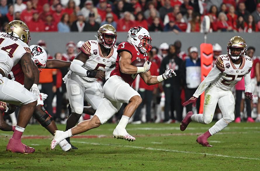 Junior running back Jordan Houston runs past Seminole defenders during the Wolfpack's home football game against Florida State on Saturday, Oct. 8, 2022 at Carter-Finley Stadium. The Wolfpack beat the Seminoles 19-17.