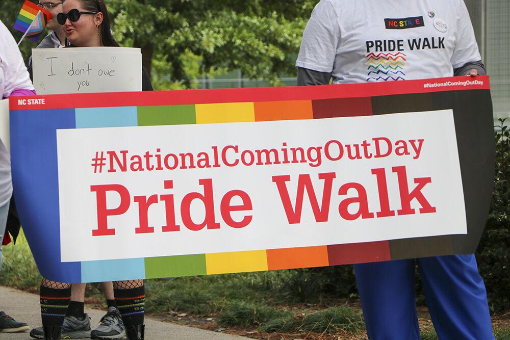 Members of the NC State community hold a sign during the Pride Walk on Monday, Oct. 3, 2022 around main campus. The Pride Walk served as a kick off of LGBTQ+ History Month.