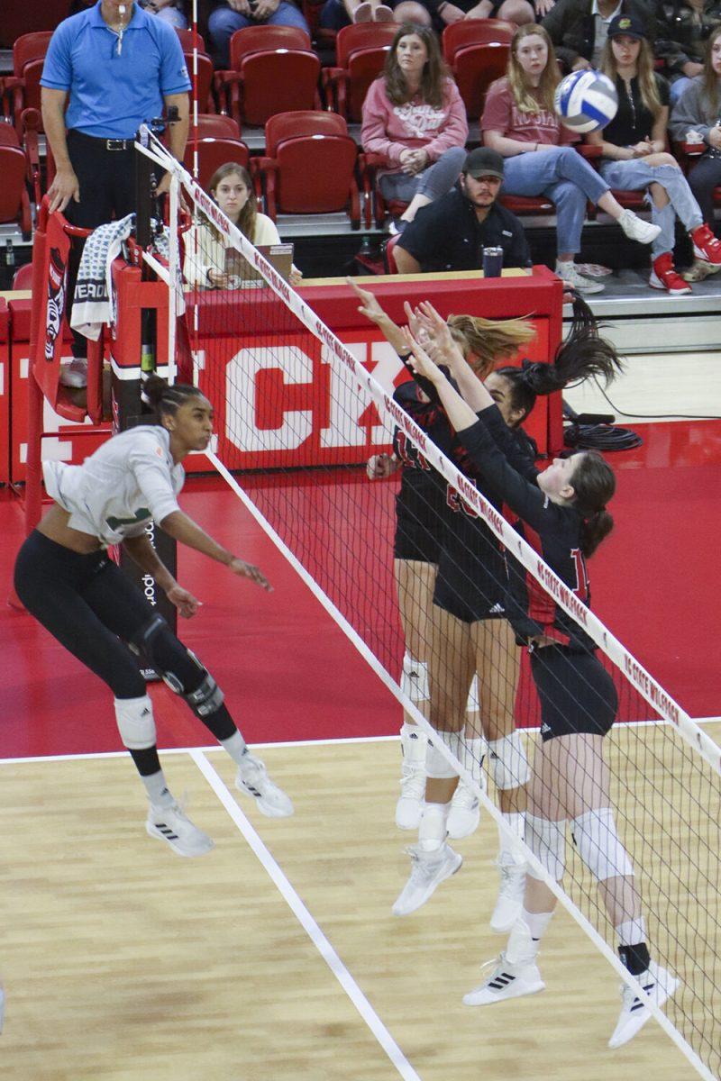 Outside hitter Martyna Leoniak, middle blocker Riley Shaak, and opposite hitter Amanda Rice jump to block a spike from their opponent during the match against Miami on Sunday,&#160;Oct. 2, 2022 in Reynolds Coliseum. The Wolfpack beat the Hurricanes 3-1.