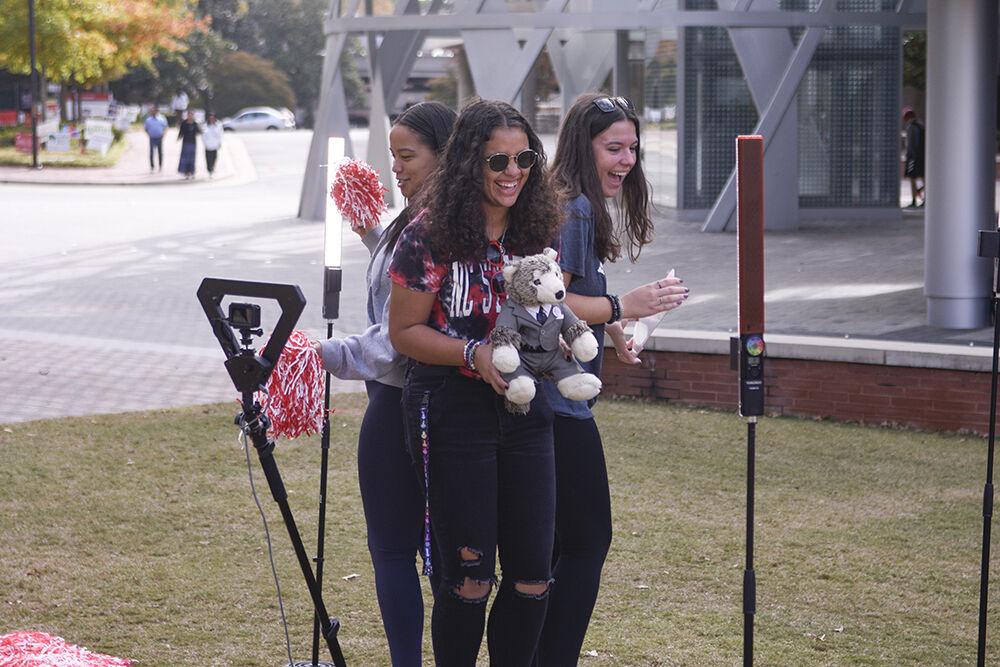 Alicia Bowling, a second-year studying biology, Sydney Cassels, a second-year studying sociology, and Emilia Monrad, a second-year studying marine science, all pose for a 360 degree video with their mini Tuffy plush at the Red and White Week Kickoff on Monday, Oct. 31, 2022 at Stafford Commons. The Red and White Week Kickoff was a celebration of the beginning of NC State&#8217;s annual homecoming week.