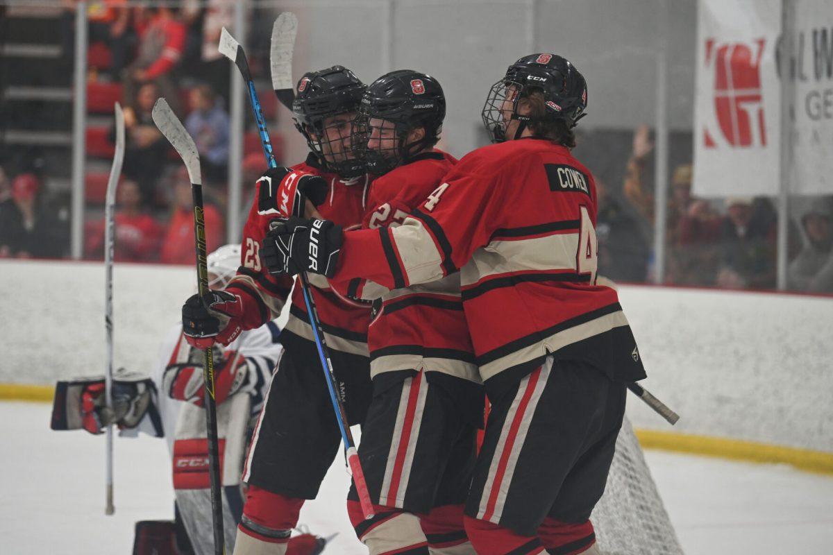 (Left) Senior defenseman Victor Hugo and (right) junior defenseman Jackson Cowen celebrate sophomore forward Emery Oliver's goal during the game against UNC-Wilmington at Wake Competition Center on Friday, Oct. 14, 2022. Oliver had one goal. The Icepack won 4-1.