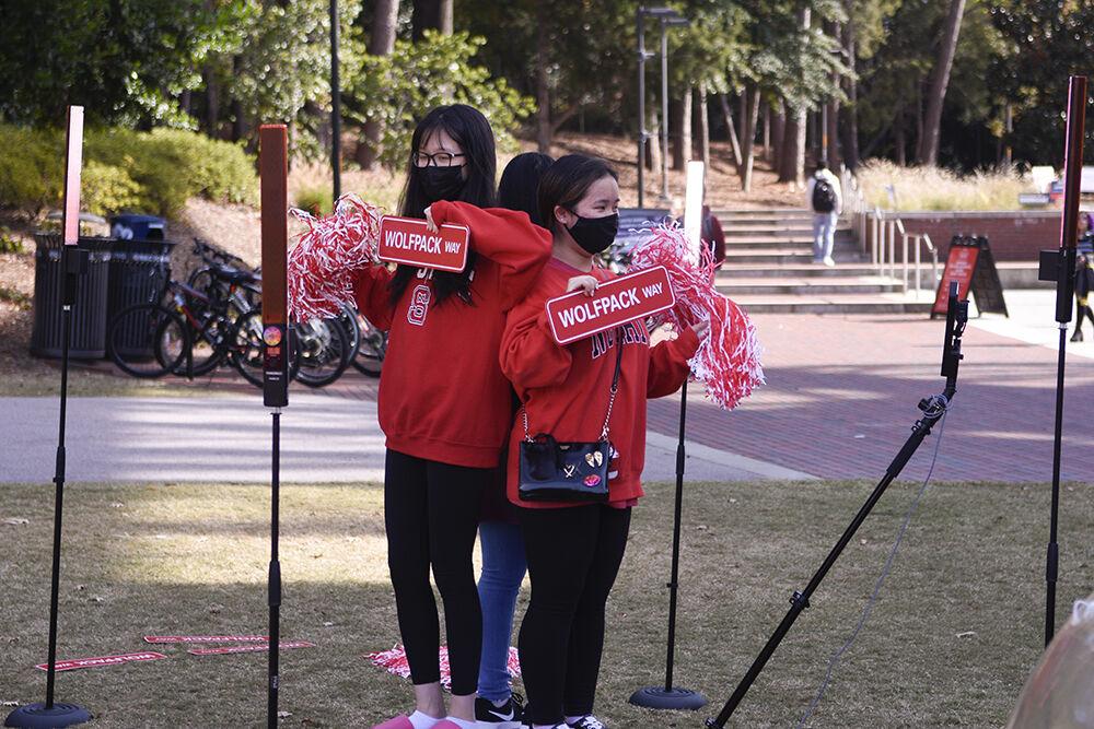 Grace Liu, a first-year studying math education, Meihui Wu, a first-year studying accounting, and Yiling Diep, a first-year student studying information technology, pose for a 360 degree video at the Red and White Week Kickoff on Monday, Oct. 31, 2022 at Stafford Commons. The Red and White Week Kickoff marks the start of NC State&#8217;s homecoming week.