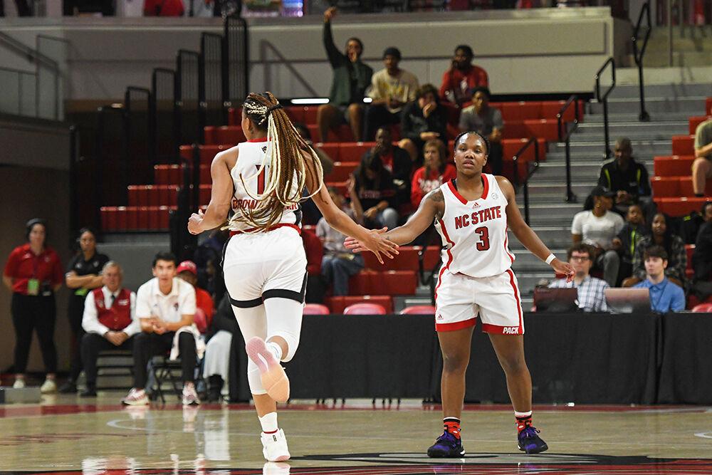 Senior wing Jakia Brown-Turner (left) high-fives junior guard Diamond Johnson (right) after scoring a point in the exhibition game against UNC-Pembroke on Thursday, Nov. 3, 2022 inside Reynolds Coliseum. The Wolfpack won the exhibition game 81-22.