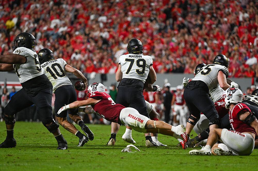 Junior linebacker Drake Thomas tackles Wake Forest quarterback Sam Hartman in the game against the Demon Deacons on Saturday, Nov. 5, 2022 at Carter-Finley Stadium. Thomas had three tackles during the game.&#160;NC State defeated Wake Forest 30-21.