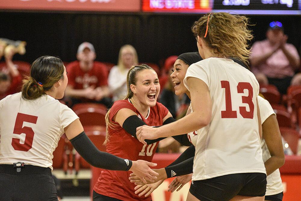 The NC State volleyball team celebrates scoring a point versus Virginia at Reynolds Coliseum on Wednesday, Nov. 23 2022. NC State beat Virginia 3-1.