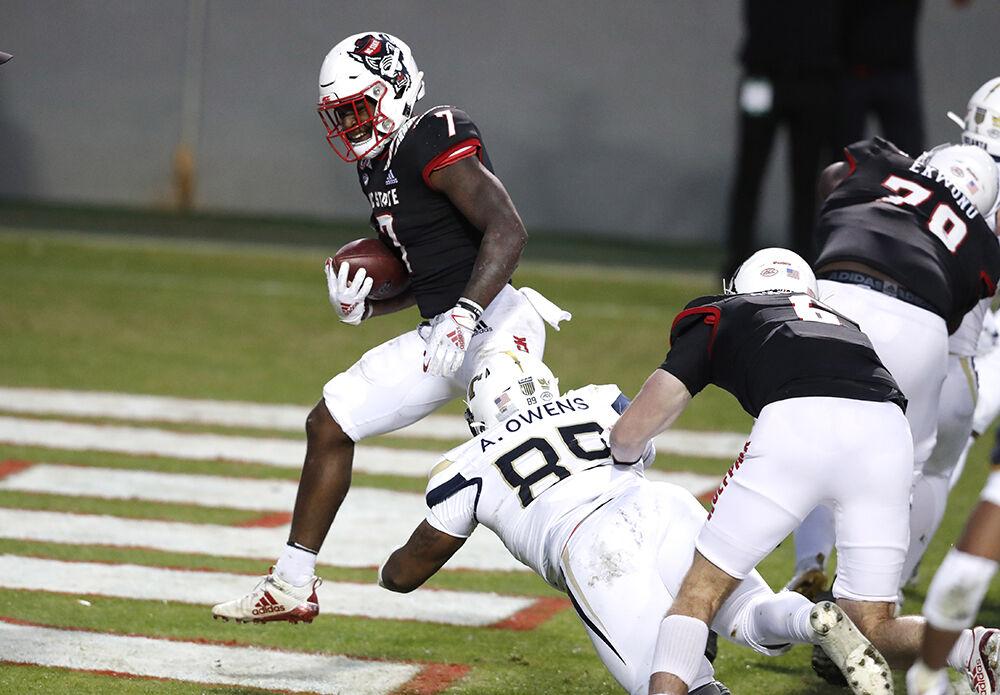 N.C. State running back Zonovan 'Bam' Knight (7) scores on a five-yard touchdown run during the first half of N.C. State&#8217;s game against Georgia Tech at Carter-Finley Stadium in Raleigh, N.C., Saturday, Dec. 5, 2020. Georgia Tech defensive lineman Antwan Owens (89) defends.