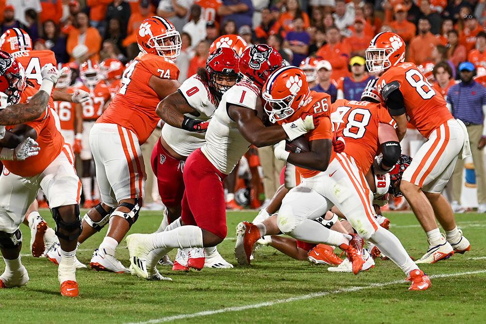 Graduate student linebacker Isaiah Moore and redshirt sophomore defensive tackle Joshua Harris tackle the ball carrier during the game against Clemson on Saturday, Oct. 1, 2022 in Clemson Memorial Stadium. Moore had ninetotal tackles during the game. The Wolfpack lost to the Tigers 30-20.