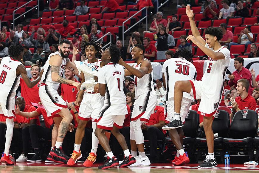 Members of the NC State men's basketball team celebrate a teammates three-pointer during the exhibition game against Lees-McRae in PNC Arena on Wednesday, Nov. 2, 2022. The Wolfpack beat the Bobcats 107-59.
