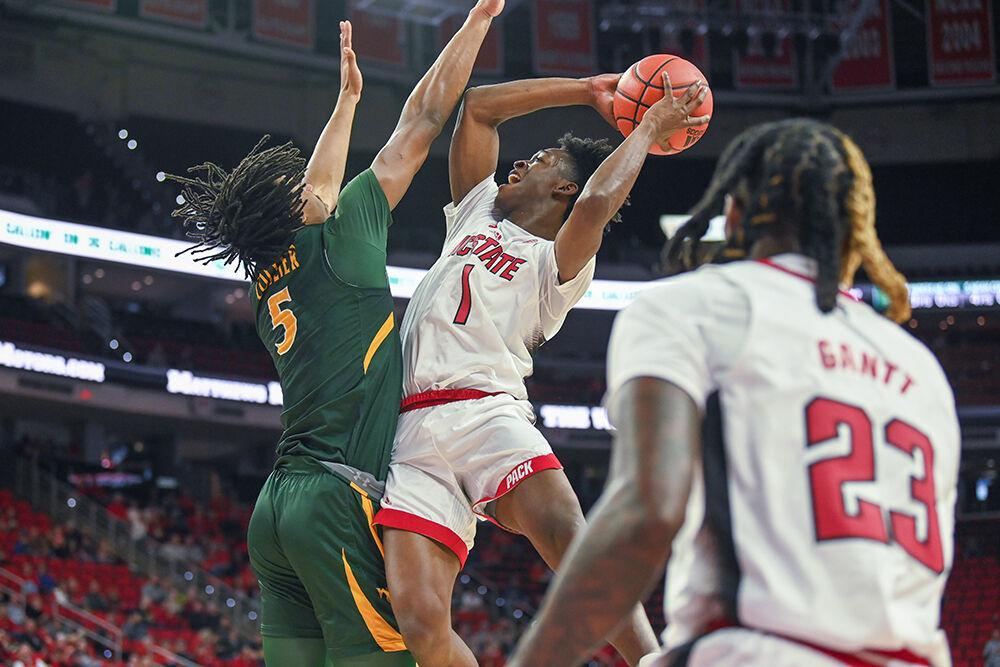 Graduate student guard Jarkel Joiner jumps to dunk the ball as his teammate, junior forward Greg Grantt, watches during the game against William &amp; Mary in PNC Arena on Tuesday, Nov. 29, 2022. Joiner had 11 points. The Wolfpack won 85-64.