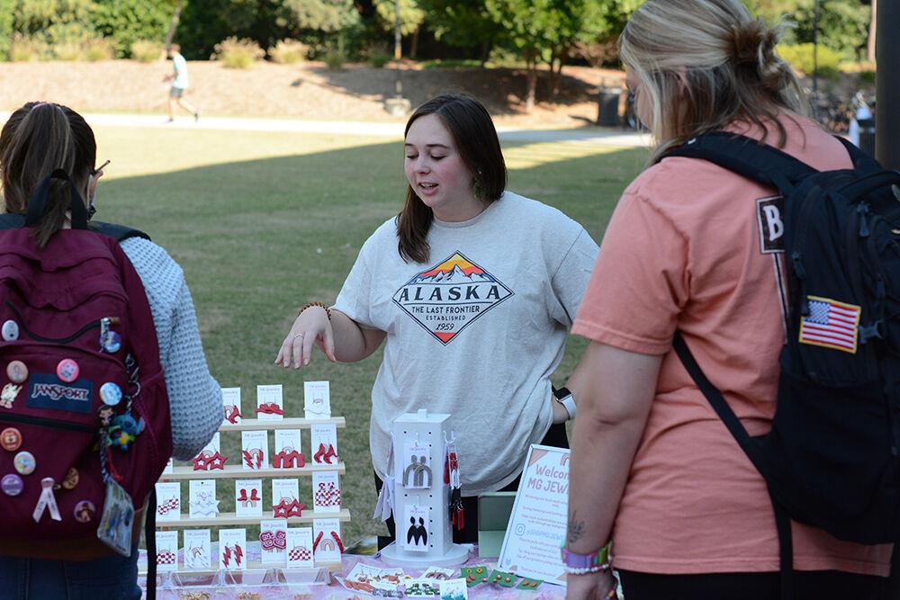 Mackenzie Marino, a fourth-year studying industrial and systems engineering and Student Made creator, talks to interested students at the NC State Student Made pop-up shop outside Talley Student Union on Monday, Oct. 17, 2022. NC State Student Made works with student creatives to offer them a platform to sell their artwork and reach a larger audience.