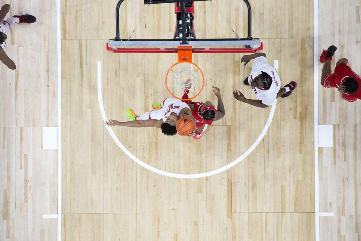 Freshman guard LJ Thomas hits the ball away from the hoop during the game against Louisville at PNC Arena on Thursday, Dec. 22, 2022. Thomas made one free throw. The Wolfpack beat the Cardinals 76-64.