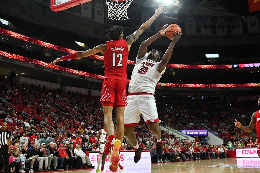 Graduate forward D.J. Burns Jr. jumps to throw in the ball during the game against Louisville at PNC Arena on Thursday, Dec. 22, 2022. Burns made four field goals and four rebounds. The Wolfpack beat the Cardinals 76-64.