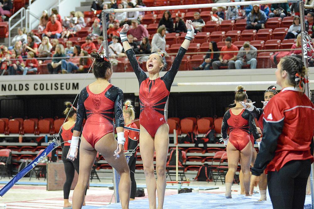 Freshman gymnast Kailee Adomaites cheers before the uneven bars event during the meet against Pitt and George Washington University at Reynolds Coliseum on Saturday, Jan. 21, 2023. Adomaites scored a 9.800 on her uneven bars routine. NC State beat Pitt and George Washington with an overall score of 196.650.