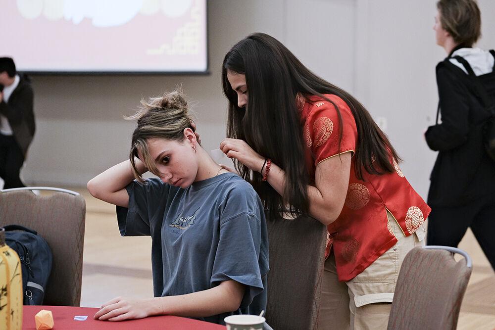 (Left to right) Claire Hauser, a fourth-year studying zoology, and Daniella Velandia, a third-year studying human biology, apply temporary tattoos during the Lunar New Year celebration in Talley Student Union on Wednesday, Jan. 25, 2023. Students celebrated the event by engaging in multiple Asian activities.